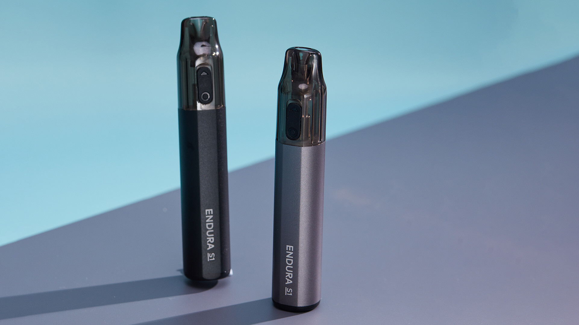 Two ENDURA S1 rechargeable disposable vape pens, one in black and one in silver, showcasing their sleek design and easy identification features.